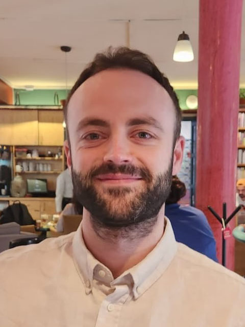 Doctoral Research Reuben Shapland earing a beige shirt